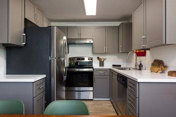 A modern kitchen with a black fridge and stainless steel appliances.